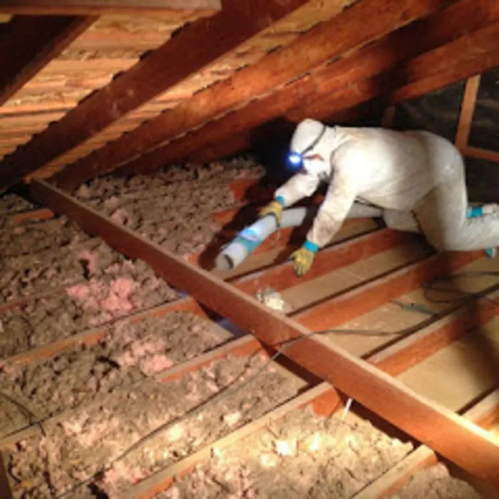 Technician installing insulation in an attic