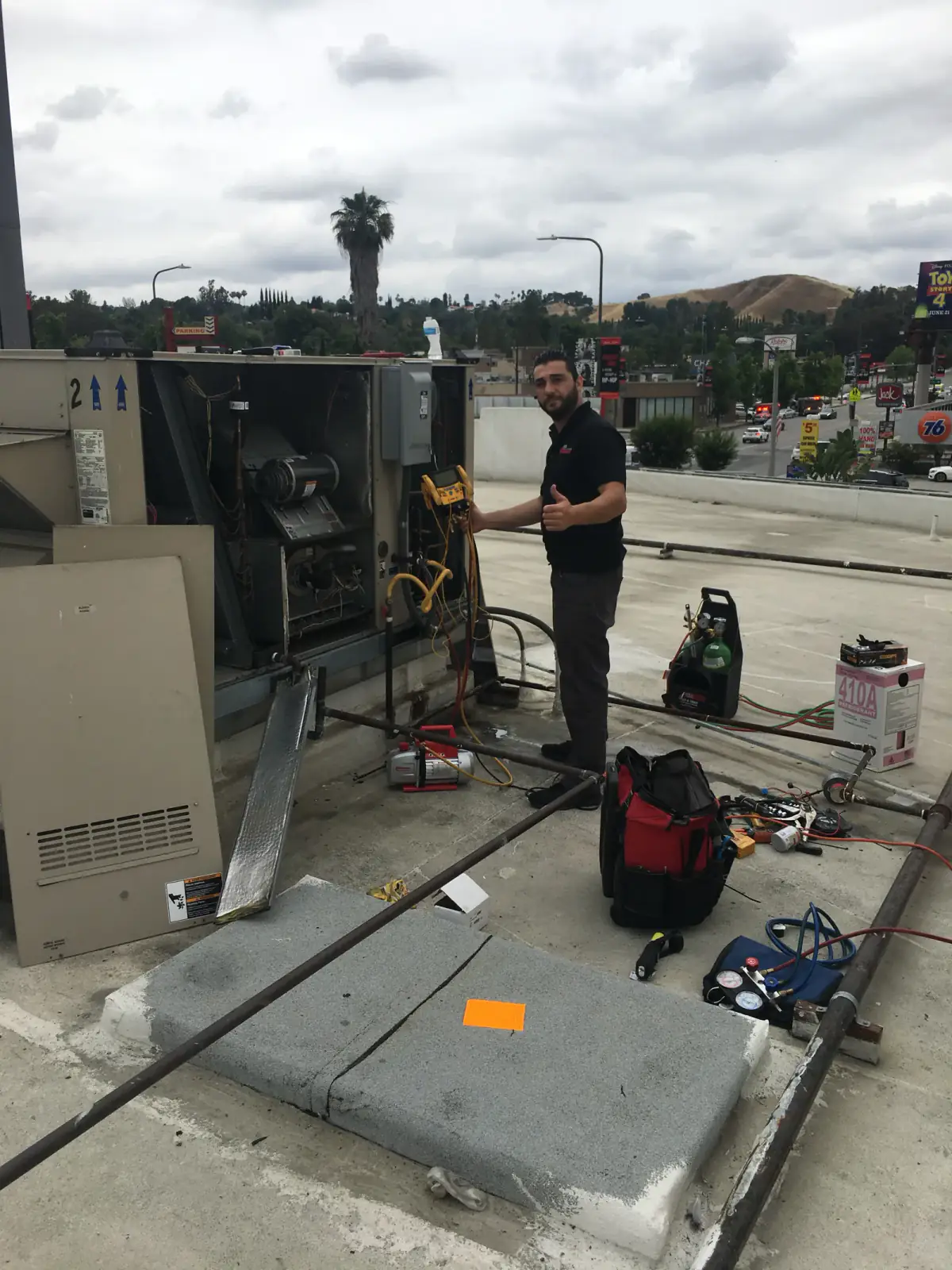 Technician servicing a rooftop HVAC unit