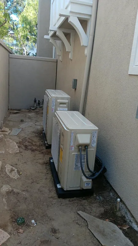 Two outdoor HVAC condenser units on pads beside a Pasadena home