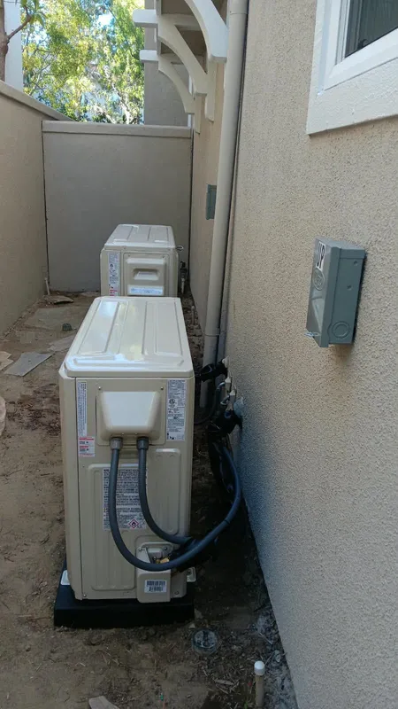 Outdoor HVAC units with line sets along the wall of a Pasadena home